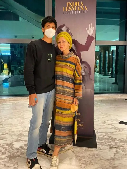 Kembali tampil dengan hijab bergaya turban, kali ini Wanda memadukan turtleneck dress bergaris nuansa kuning, yang dipasangkan dengan hijab warna kuning, dan sneakers putih. (Instagram/wanda_hamidah).