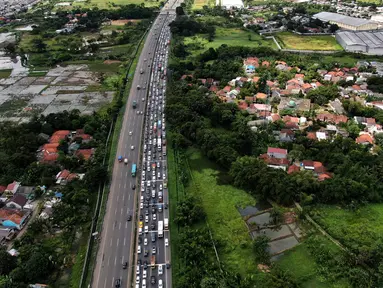 Pantauan udara kemacetan di gerbang masuk tol Cikupa, Tangerang, Banten, Kamis (28/4/2022). Memasuki H-4 Hari Raya Idulfitri 1443 H atau Lebaran 2022, kendaraan pemudik dengan menggunakan kendaraan pribadi mengular di pintu tol Cikupa arah Merak. Kemacetan terjadi kurang lebih hingga dua km meter. (Liputan6.com/Angga Yuniar)
 