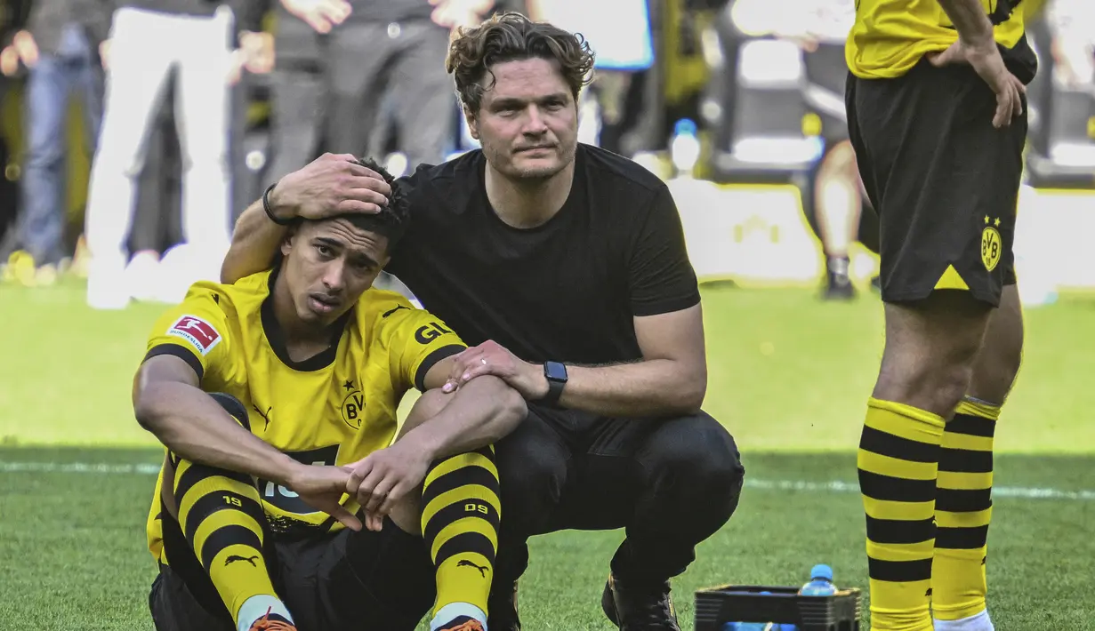 Pelatih Borussia Dortmund, Edin Terzic menghibur pemainnya, Jude Bellingham setelah berakhirnya laga menghadapi FSV Mainz pada laga pekan terakhir Liga Jerman 2022/2023 di Dortmund, Jerman (27/5/2023). Ditahan imbang FSV Mainz 2-2, Borussia Dortmund harus merelakan gelar juara Liga Jerman 2022/2023 menjadi milik Bayern Munchen. (AP Photo/Michael Probst)