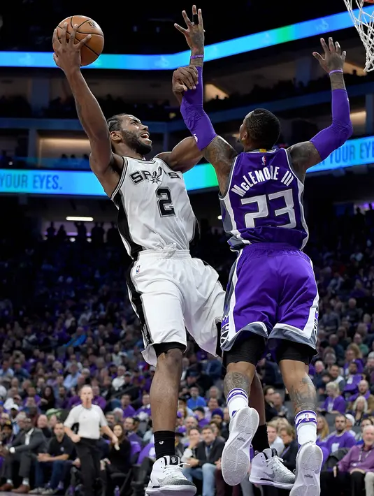 Aksi pemain San Antonio Spurs, Kawhi Leonard #2 melakukan tembakan saat dihadang pemain Sacramento Kings, Ben McLemore #23 pada ajang NBA di Golden 1 Center, Sacramento, California, Kamis (27/10/2016). (AFP/Thearon W. Henderson/Getty Images)