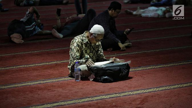 Jemaah membaca kitab suci Alquran usai salat di Masjid Istiqlal, Jakarta, Selasa (7/5/2019). Umat muslim meningkatkan ibadah pada bulan suci Ramadan dengan membaca Alquran (tadarus), salat berjemaah, berdoa, dan zikir di masjid. (Liputan6.com/Faizal Fanani)