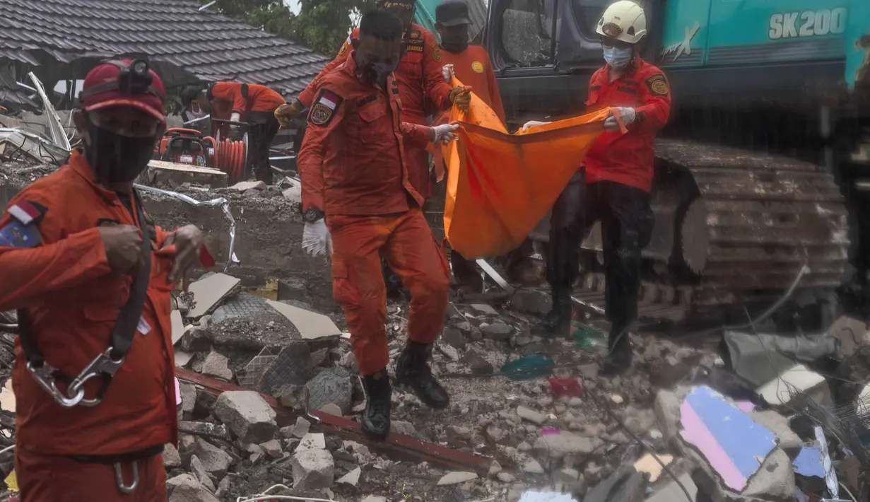 Tim penyelamat membawa kantong mayat berisi korban gempa bumi di Mamuju, Sulawesi Barat, Jumat (15/1/2021). Gempa bermagnitudo 6,2 mengguncang Mamuju, Sulawesi Barat. (AP/Yusuf Wahil)