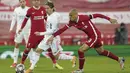 Gelandang Real Madrid, Luka Modric berusaha melewati gelandang Liverpool, Fabinho pada pertandingan leg kedua babak perempat final Liga Champions di stadion Anfield di Liverpool, Inggris, Kamis (14/4/2021). Liverpool bermain imbang atas Madrid 0-0. (AP Photo/Jon Super)