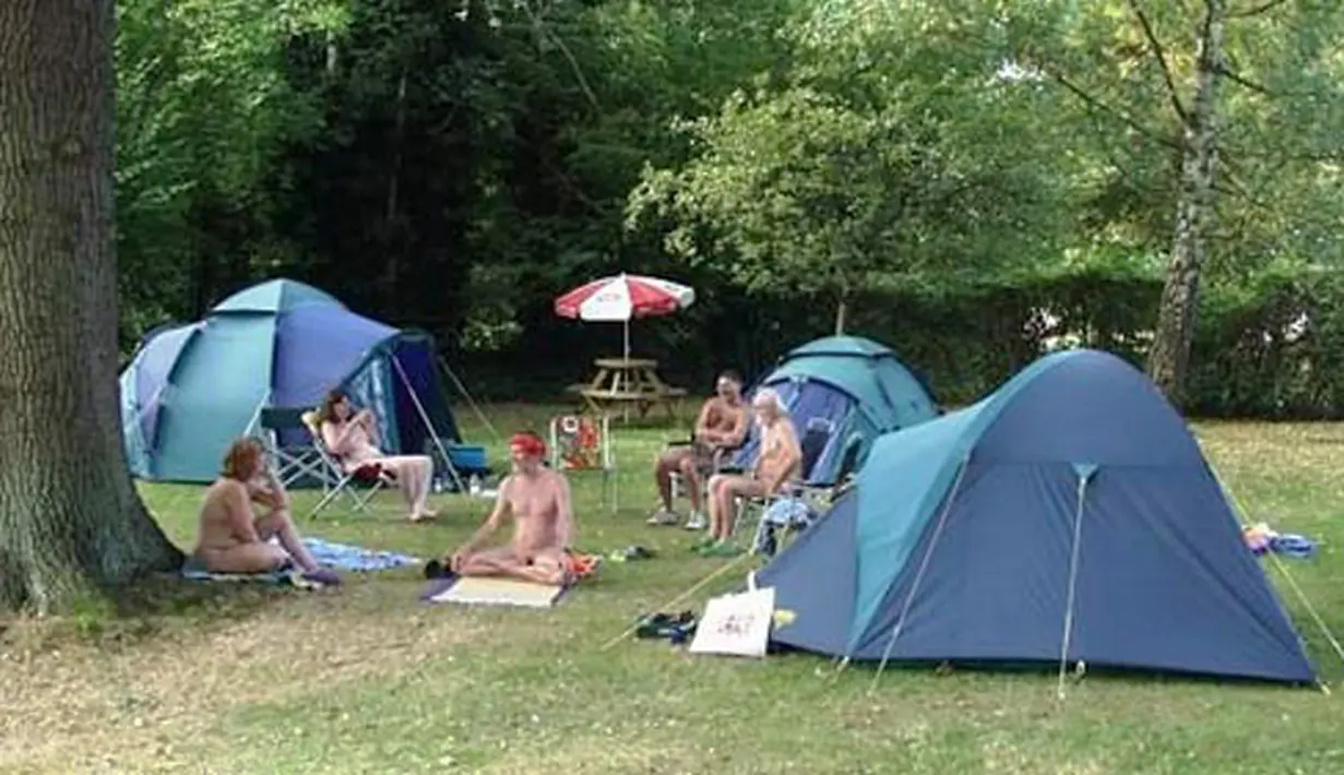 Sejumlah penduduk saat berkemping di Desa Spielplatz, London, Inggris. Lebih dari 100 orang dari 30 rumah di desa ini telah menjalani hidup bertelanjang selama puluhan tahun dan memberikan kesempatan kepada orang lain untuk bergabung. (naturistguide.eu)
