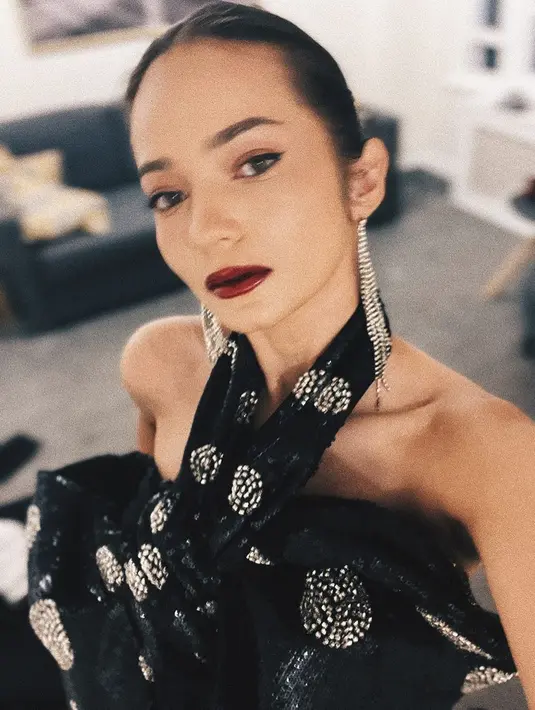 Enzy Storia tampil menawan dalam balutan dress dengan detail halter-neck, berwarna hitam. Rambut ditata sleek dipadu dengan pulasan lipstik merah. [Foto: Instagram/enzystoria]