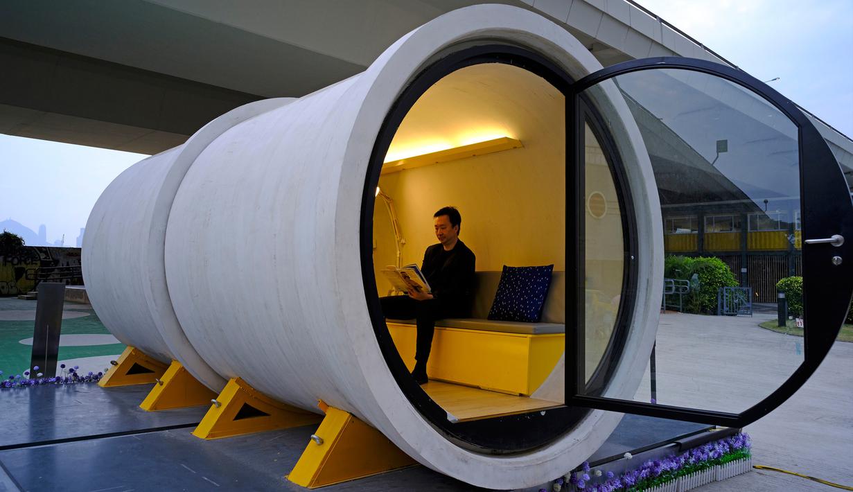Seorang arsitek James Law sedang membaca di dalam rumah tabung OPod di kawasan industri Kwun Tong, Hong Kong (13/3). James Law ingin membuat rumah impian dari pipa yang terjangkau untuk warga Hong Kong. (AP Photo / Vincent Yu)
