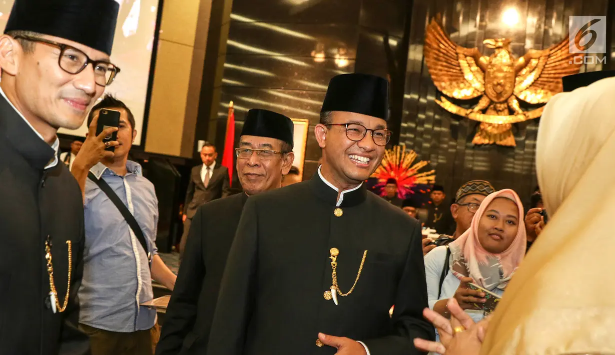 Gubernur dan Wakil Gubernur DKI Jakarta Anies Baswedan (tengah) dan Sandiaga Uno (kiri) berbincang usai rapat istimewa bersama DPRD Provinsi DKI Jakarta, Jumat (22/6). (Liputan6.com/Immanuel Antonius)