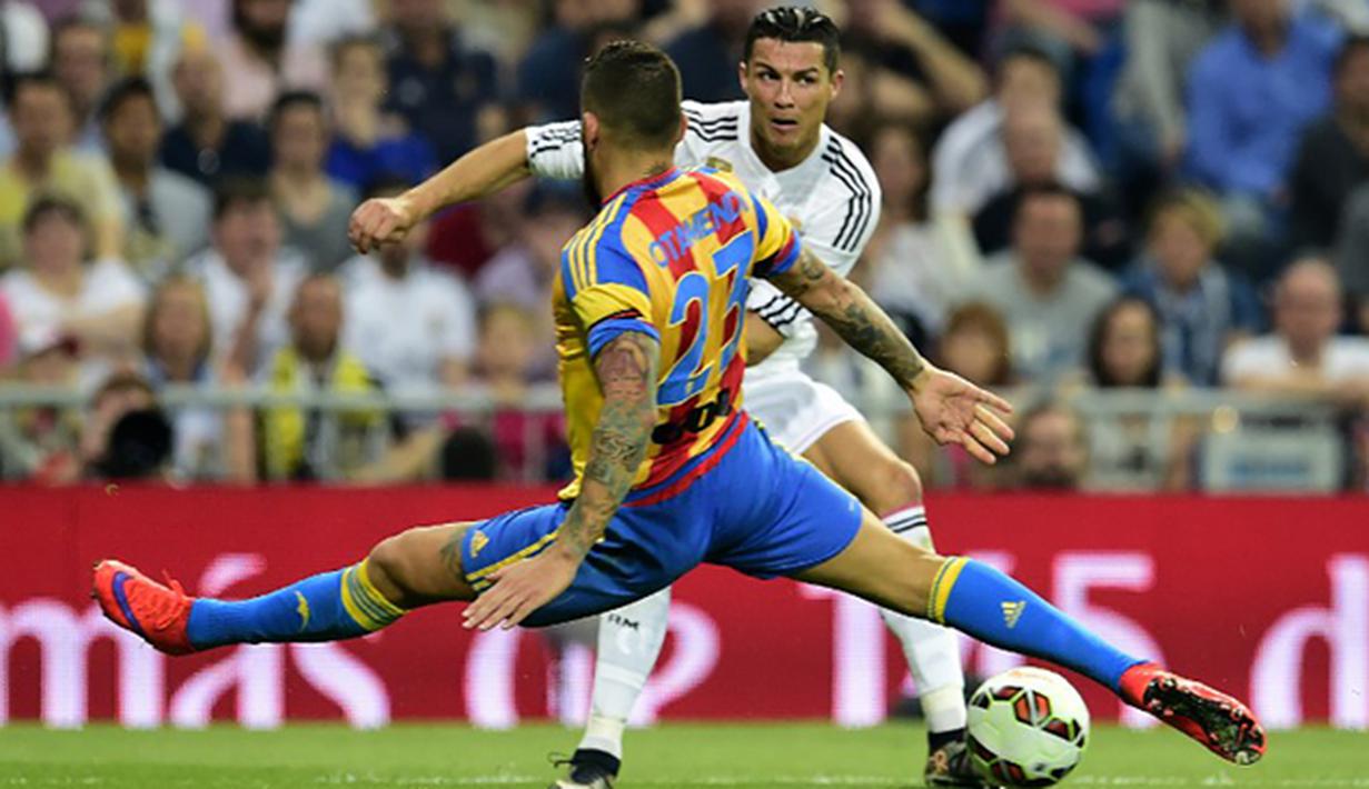 Nicolas Otamendi menghadang bintang Real Madrid, Cristiano Ronaldo pada laga La Liga di Stadion Santiago Bernabeu, Spanyol, Sabtu (9/5/2015). Otamendi musim lalu sukses membawa Valencia berada di peringkat empat klasemen. (AFP Photo/Gerard Julien)