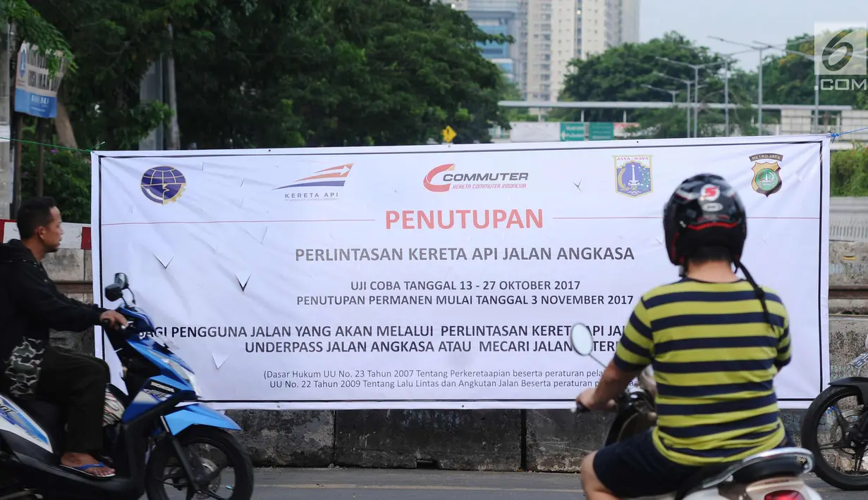 Pengendara melintas di depan spanduk sosialisasi penutupan perlintasan kereta di Jalan Angkasa, Jakarta, Minggu (15/10). Penutupan secara permanen perlintasan KA di Jalan Angkasa akan dilakukan pada 3 November mendatang. (Liputan6.com/Helmi Fithriansyah)