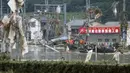 Anggota Japan Ground Self-Defense Force mengevakuasi warga ke tempat yang lebih aman menggunakan perahu di Desa Kuma, Prefektur Kumamoto, Jepang, Minggu (5/7/2020). Hujan deras memicu banjir dan tanah longsor di sejumlah wilayah Jepang. (Kyodo News via AP)