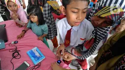 Murid-murid SLB mengikuti tes STIFIn di Sekolah Luar Biasa A Pembina Tingkat Nasional, Lebak Bulus, Jakarta, Selasa (17/12/2019). Tes tesebut dilakukan melalui menscan  ksepuluh ujung jari dengan mengambil waktu tidak lebih dari satu menit. (merdeka.com/Arie Basuki)