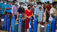 Orang-orang antre menunggu di lokasi yang menyumbangkan oksigen secara gratis di Yangon, Myanmar pada 14 Juli 2021. Mereka putus asa mencari oksigen untuk menjaga orang yang dicintai tetap bernapas ketika gelombang corona covid-19 menerjang negara yang dilanda kudeta itu. (Ye Aung THU/AFP)