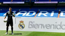 Kiper baru Real Madrid, Andriy Lunin berpose di lapangan saat presentasi di Stadion Santiago Bernabeu, Madrid, Spanyol, Senin (23/7). Kiper berusia 19 tahun ini didapatkan El Real dari klub Liga Ukraina, FC Zorya Luhansk. (JAVIER SORIANO/AFP)