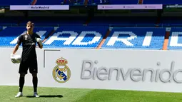Kiper baru Real Madrid, Andriy Lunin berpose di lapangan saat presentasi di Stadion Santiago Bernabeu, Madrid, Spanyol, Senin (23/7). Kiper berusia 19 tahun ini didapatkan El Real dari klub Liga Ukraina, FC Zorya Luhansk. (JAVIER SORIANO/AFP)