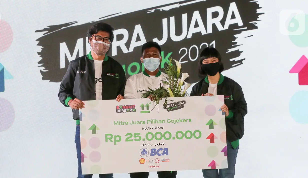 Jubeironi, Mitra Driver GoRide (tengah) menerima penghargaan Mitra Juara Gojek Pilihan Gojekers didampingi Chief Food Officer Gojek Catherine Hindra Sutjahyo dan Chief Transport Officer Gojek Raditya Wibowo pada Apresiasi Mitra Juara Gojek di Jakarta (5/11/2021). (Liputan6.com/Fery Pradolo)