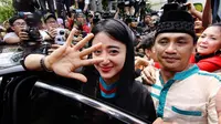 Sebelum masuk ke dalam mobil, Dewi Perssik melambaikan tangan pada media yang mengelilinginya dengan senyum menahan tangis, Rabu (14/05/14). (Liputan6.com/Faizal Fanani)