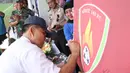 Pendiri Patriot 165 FC, Sudirman, membukukan tanda tangan pada logo klub  di Lapangan ABC Senayan, Jakarta, Rabu (28/3/2018). Acara ini dalam rangkaian peluncuran Patriot 165 FC. (Bola.com/Asprilla Dwi Adha)