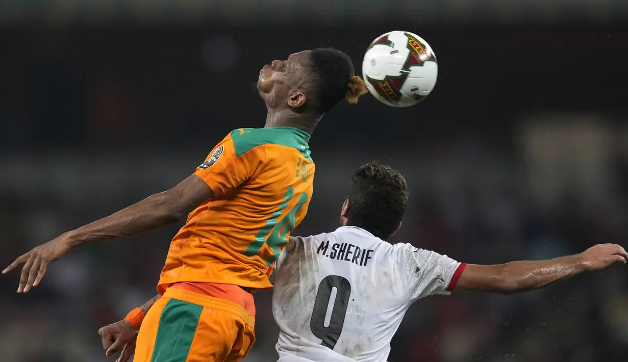 Bek Pantai Gading Simon Deli melompat saat berebut bola dengan penyerang Mesir Mohamed Sherif pada babak 16 besar Piala Afrika 2021 di Stade Omnisport de Douala, Rabu (26/1/2022). Mesir ke perempat final usai menyingkirkan Pantai Gading lewat drama adu penalti, 5-4 (0-0). (AP Photo/Themba Hadebe)