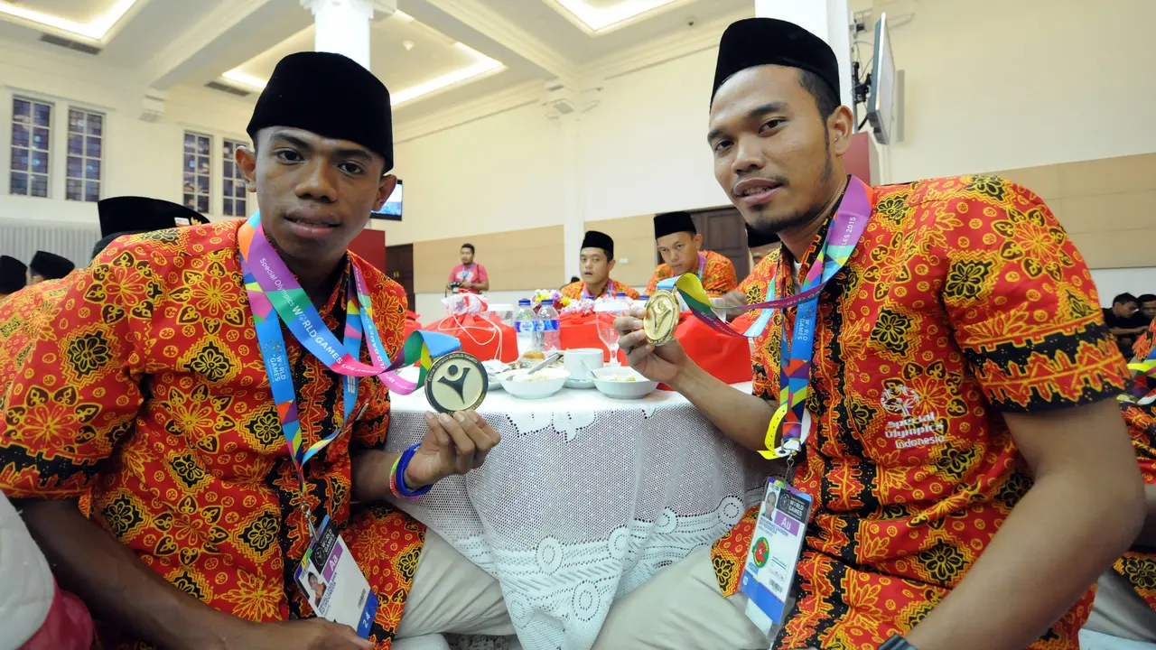 Brusli Lekilawa (kiri) dan M Zakroni memamerkan medali dari cabang sepak bola di SOWSG XIV