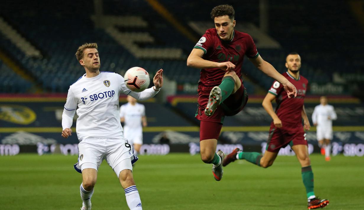 Bek Wolverhampton Wanderers, Max Kilman, berebut bola dengan striker Leeds United, Patrick Bamford, pada laga Liga Inggris di Elland Road, Selasa (20/10/2020) dini hari WIB. Wolves menang 1-0 atas Leeds United. (AFP/Alex Pantling/pool)