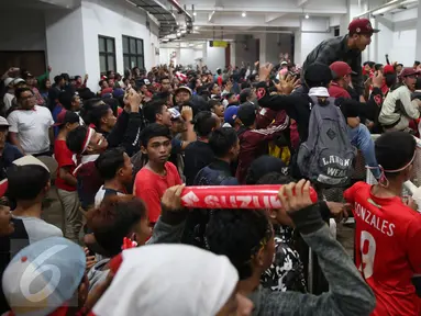 Pendukung Timnas Indonesia memaksa masuk ke dalam tribun saat berlangsungnya leg pertama final Piala AFF 2016 di Stadion Pakansari, Bogor, Rabu (14/12). Kapasitas tribun yang sudah penuh membuat petugas jaga menutup pintu masuk. (Liputan6.com/Johan Tallo)