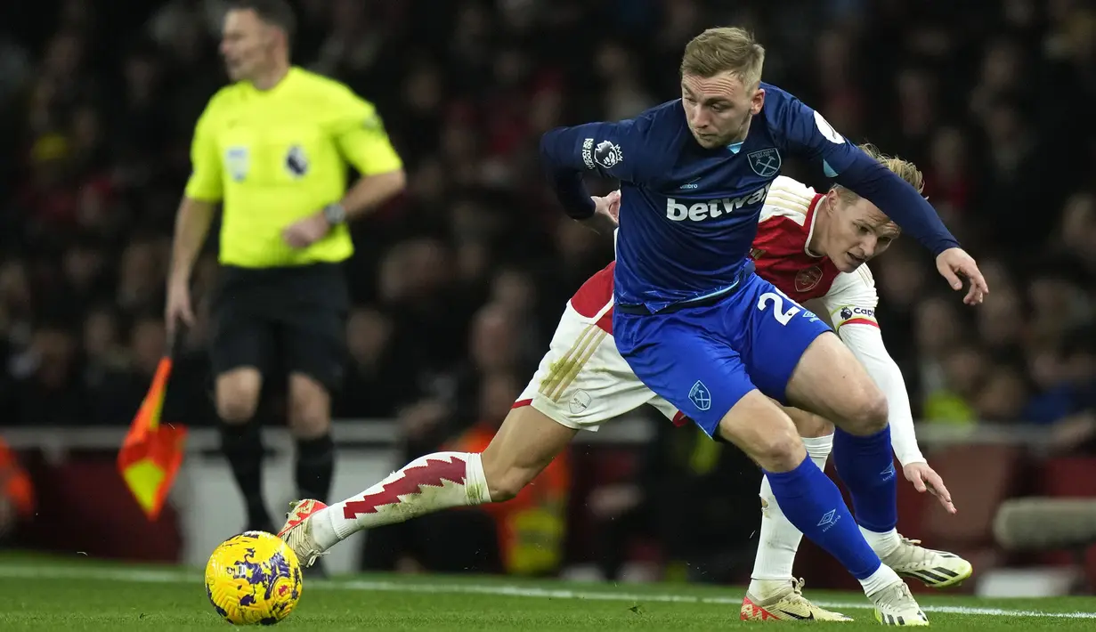 Pemain West Ham United, Jarrod Bowen (depan) berebut bola dengan pemain Arsenal, Martin Odegaard pada laga lanjutan Liga Inggris 2023/2024 di Emirates Stadium, London, Inggris, Jumat (29/12/2023) dini hari WIB. (AP Photo/Alastair Grant)