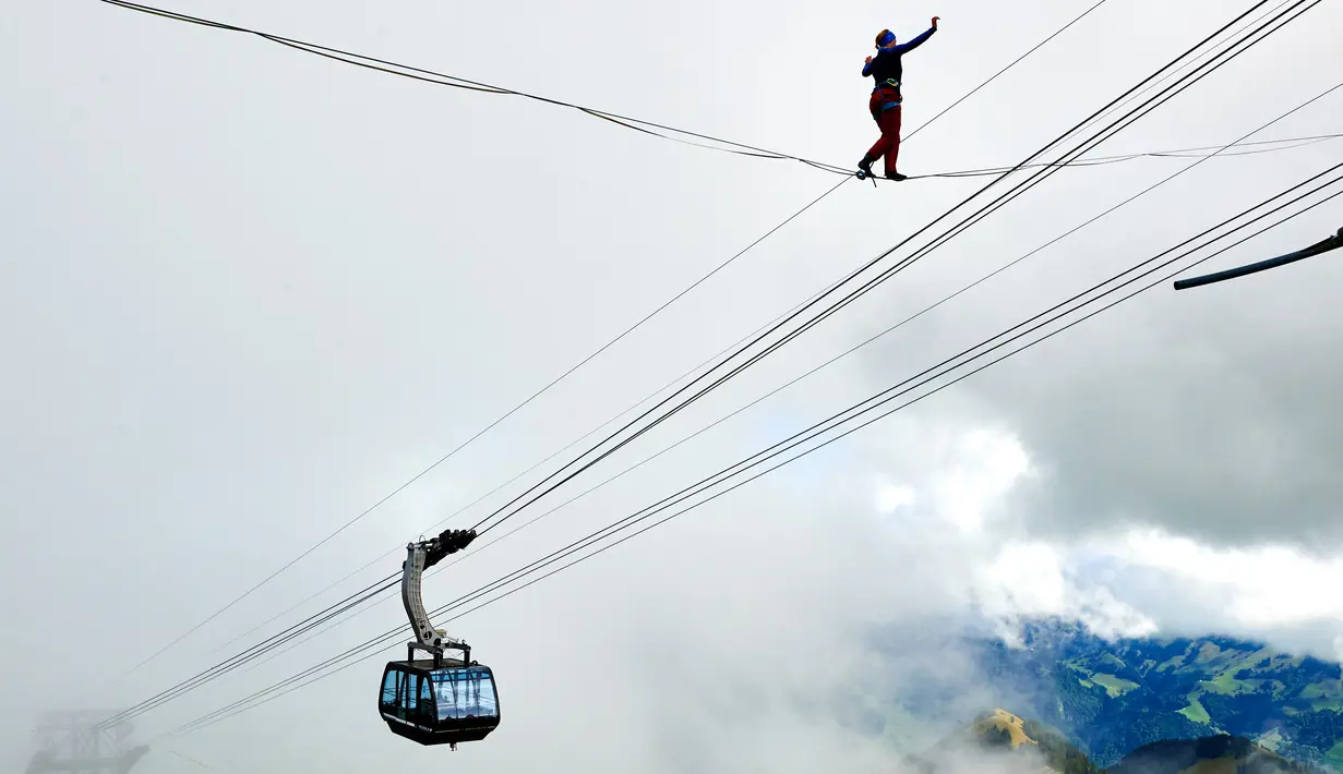 Audhild Hogasen dari Norwegia berjalan diatas tali saat acara Highline Extreme di puncak Moleson, Swiss (15/9). Perlombaan berjalan di seutas tali diatas ketinggian ini diikuti oleh lima puluh slackliner terbaik Dunia. (AFP Photo/Michael Buholzer)