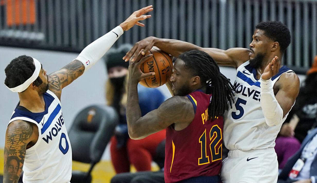 Pebasket Cleveland Cavaliers, Taurean Prince, berusaha melewati pebasket Minnesota Timberwolves, D'Angelo Russell dan Malik Beasley pada laga NBA di Rocket Mortgage FieldHouse, Senin (1/2/2021). Cavaliers menang dengan skor 100-98. (AP/Tony Dejak)