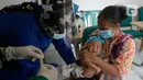 Perawat dibantu kader Posyandu menyuntikan vaksin campak, vaksin pentabio berisi vaksin DPT, Hepatitis B dan Haemophilus Influenzae dan Imunisasi Polio terhadap anak di RW 09, Kelurahan Pondok Benda, Tangerang Selatan, Senin (14/12/2020). (merdeka.com/Dwi Narwoko)