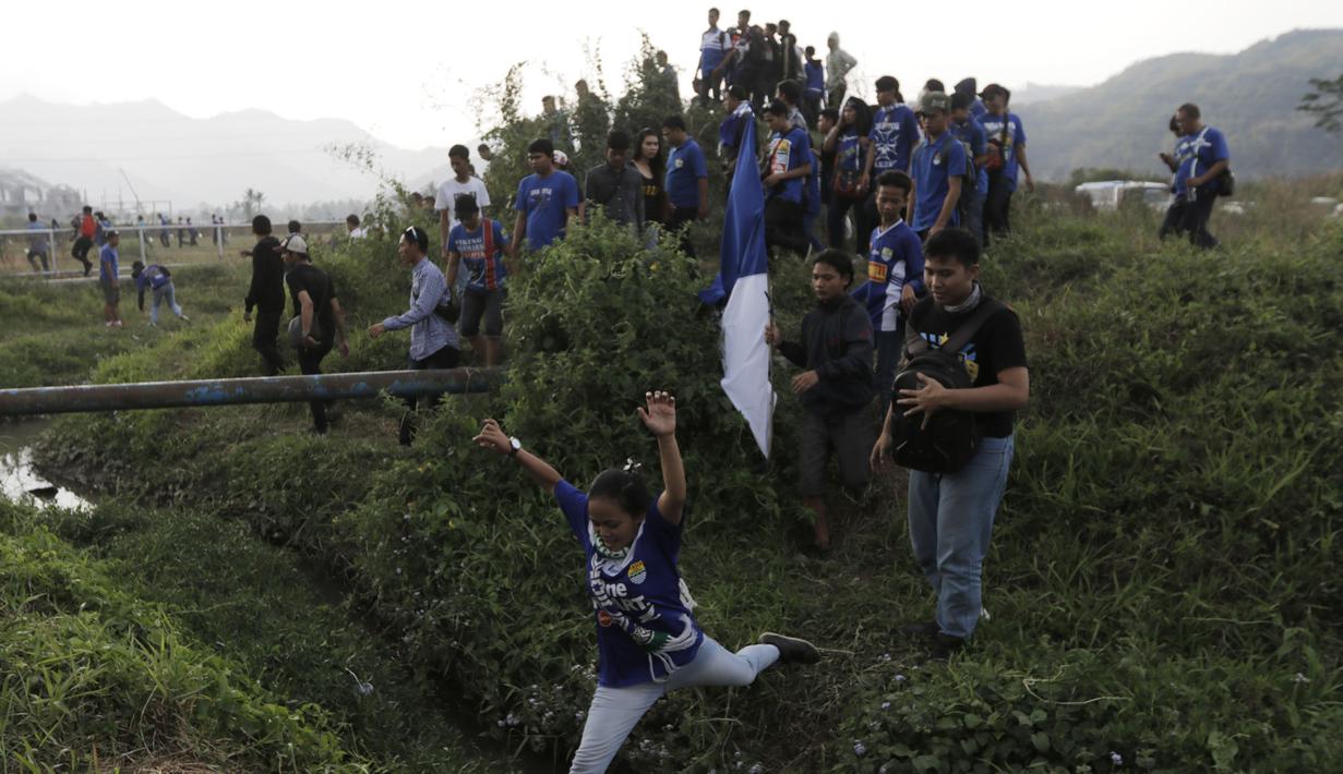 Seorang Bobotoh melompati parit untuk menuju Stadion Si Jalak Harupat, Bandung. (Bola.com/Vitalis Yogi Trisna)