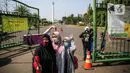 Sejumlah warga berswafoto di depan kawasan Monumen Nasional (Monas), Jakarta, Minggu (26/7/2020). Sejumlah warga mulai mengunjungi kawasan Monas meski masih ditutup sementara di masa PSBB transisi. (Liputan6.com/Faizal Fanani)