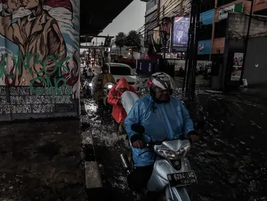Sejumlah kendaraan menerobos Banjir yang menggenangi kawasan Seskoal - Cipulir, Jakarta, Selasa (4/4/2022). Hujan yang mengguyur wilayah Ibu Kota Jakarta mengakibatkan banjir menggenangi kawasan Simpang Seskoal, Kebayoran Lama, Jakarta. Banjir setinggi 50cm - 1 meter disebabkan saluran pembuangan berukuran kecil tersumbat. (Liputan6.com/Johan Tallo)
