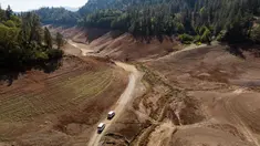 Kendaraan melintasi jalan tanah yang dulunya berada di bawah air di dekat area Bailey Cove di Danau Shasta di Lakehead, California pada (16/10/ 2022). Danau Shasta saat ini memiliki kapasitas air yang menyusut hingga 32% karena kondisi kekeringan yang terus berlanjut di seluruh barat. (JOSH EDELSON / AFP)