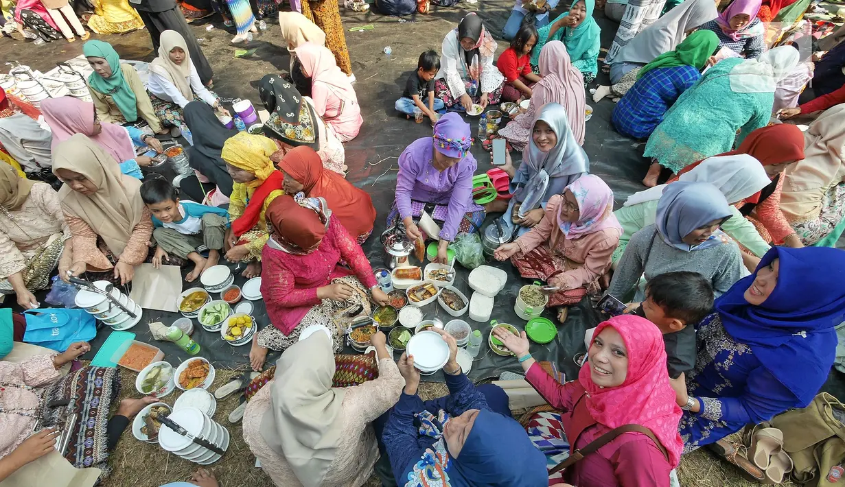 Warga menikmati makanan saat pawai pada Lebaran Orang Depok di Sawangan, Depok, Jawa Barat, Minggu (7/7/2019). Lebaran Orang Depok baru pertama kali diadakan acara tersebut untuk melestarrikan budaya dan sebagai ajang silaturahmi warga Depok. (Liputna6.com/Herman Zakharia)