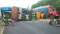 Truk berwarna oranye ini pun ditabrak dari belakang oleh truk lain yang melaju cukup cepat hingga terguling.