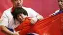 Pegulat Korea Utara, Pak long Ming, menangis usai berhasil mengalahkan pegulat Kazakstan, Zhuldyz Eshimova, pada laga Asian Games di Jakarta, Senin (208/2018).  (AP/Firdia Lisnawati)