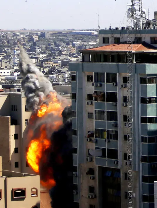 Bola api meletus dari gedung yang menampung berbagai media internasional, termasuk The Associated Press, setelah serangan udara Israel di Kota Gaza, Sabtu (15/5/2021). Serangan terjadi satu jam usai militer Israel memerintahkan orang-orang untuk mengungsi dari gedung. (Mahmud Hams/Pool Photo via AP)