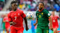 Pemain Swiss Breel Embolo (kiri) mengejar bola dengan pemain Kamerun Jean-Charles Castelletto pada pertandingan sepak bola Grup G Piala Dunia 2022 di Stadion Al Janoub, Al Wakrah, Qatar, Kamis (24/11/2022). Swiss mengalahkan Kamerun dengan skor 1-0. (AP Photo/Luca Bruno)