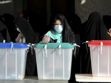 Seorang warga memberikan suaranya untuk pemilihan presiden di sebuah tempat pemungutan suara di Teheran, Iran, Jumat (18/6/2021). Warga Iran mulai memberikan suaranya dalam pemilihan presiden. (AP Photo/Ebrahim Noroozi)