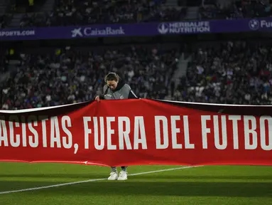 Sebuah spanduk bertuliskan dalam bahasa Spanyol, "Rasis, menjauhlah dari sepak bola" ditampilkan sebelum pertandingan La Liga Spanyol antara Valladolid vs Barcelona di stadion Jose Zorrilla Selasa, 23 Mei 2023. (AP Photo/Manu Fernandez)
