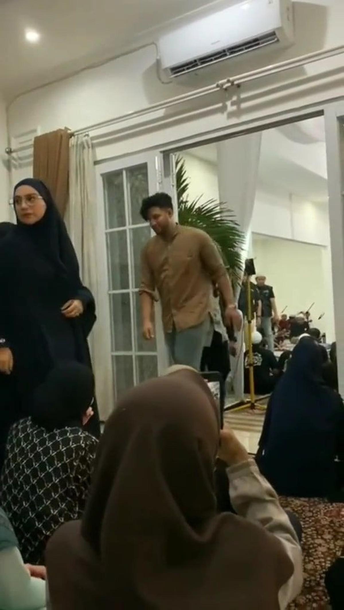 Irish Bella awalnya duduk, kemudian berdiri ketika Ammar Zoni dan rombongan artis pria lewat di ruang jemaah wanita.