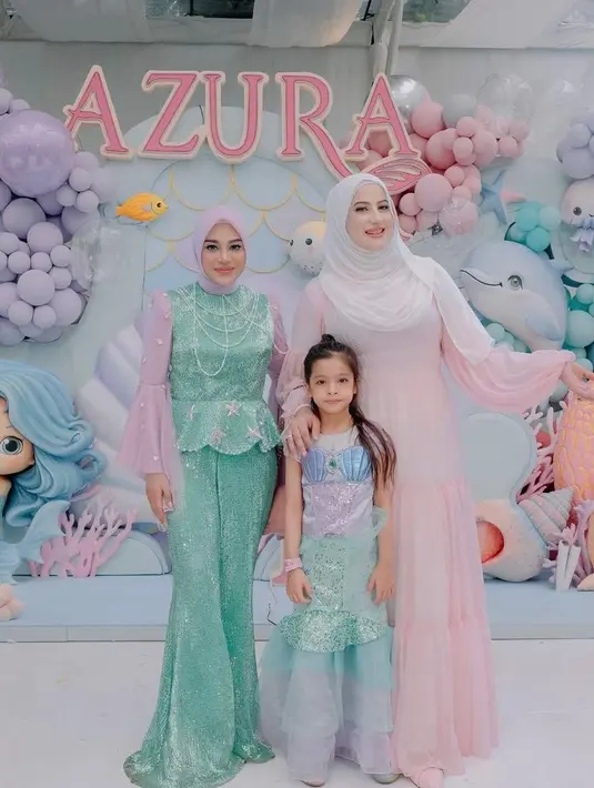 Tasyi Athasyia dan putrinya kompak tampil bagai princess. Tasyi tampil dalam balutan maxi dress warna pink pastel, sedangkan putrinya mengenakan kostum ala Princess Ariel. [@aurelie.hermansyah].