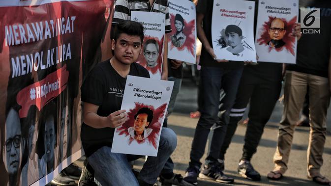 Sejumlah mahasiswa Trisakti melakukan aksi bertajuk #MerawatIngat #MenolakLupa saat car free day (CFD) di Bundaran HI, Jakarta, Minggu (5/5/2019). Aksi tersebut bertujuan untuk mengingatkan bahwa masih banyak kasus-kasus pelanggaran HAM berat yang belum terselesaikan. (Liputan6.com/Faizal Fanani)