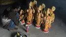 Seorang seniman India mewarnai patung dewa Hindu Rama di sebuah lokakarya di Hyderabad, India (15/3). Umat Hindu India akan merayakan festival Rama Navami yang jatuh pada tanggal 25 Maret. (AFP/Noah Seelam)