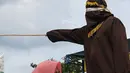 Nur Elita tampak meringis kesakitan saat petugas menyabetkan rotan ke punggungnya di halaman Masjid Baiturrahim, Ulee Lheue, Banda Aceh, Senin (28/12). Nur yang merupakan terpidana kasus khalwat mendapat hukuman 5 kali cambukan (AFP/dailymail.co.uk)