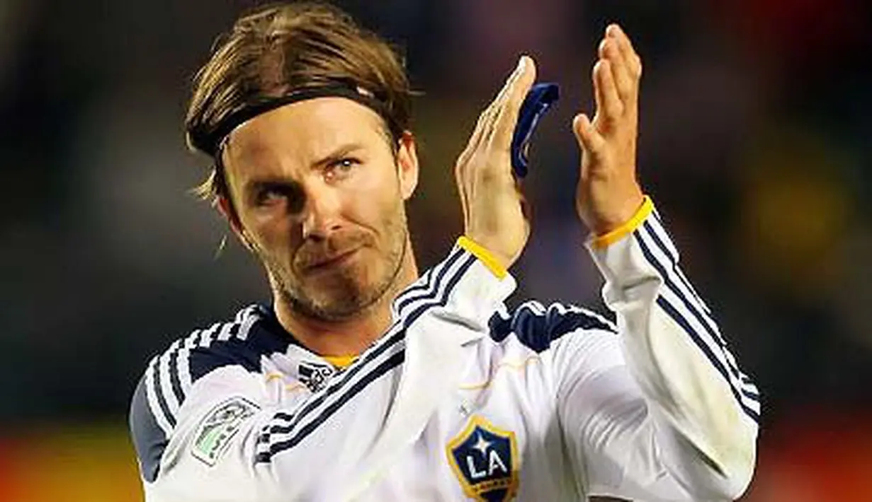 Gelandang LA Galaxy David Beckham memberi sambutan ke arah fans pada lanjutan Major League Soccer melawan DC United di Carson, California. Victor Decolongon/Getty Images/AFP