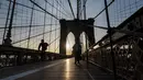 Pengendara sepeda menyeberangi Jembatan Brooklyn melintasi East River ke Manhattan di New York City, 7 Januari 2019. Brooklyn Bridge yang memiliki panjang 1.825 meter itu merupakan salah satu jembatan suspensi tertua di AS. (Johannes EISELE/AFP)