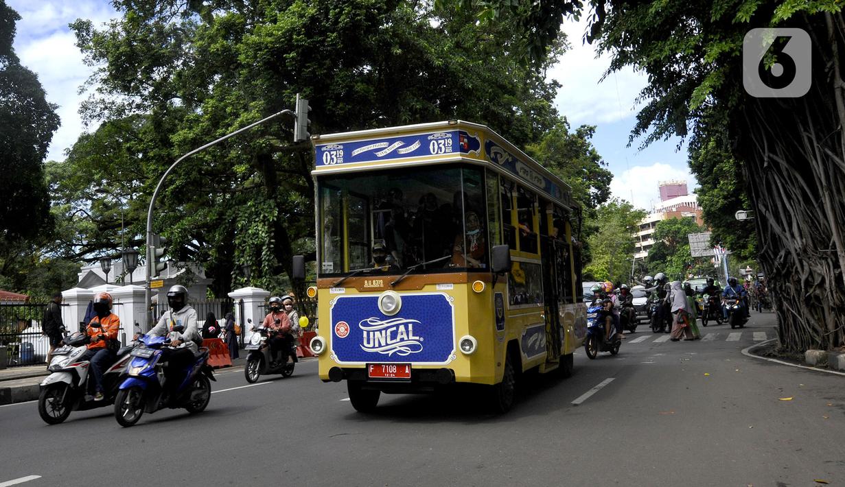 Bus wisata Uncal melintas di depan Balai Kota Bogor, Bogor, Jawa Barat, Minggu (29/5/2022). Bus wisata gratis yang disediakan untuk mengelilingi kawasan Kebun Raya Bogor setiap hari Sabtu dan Minggu ini mulai beroperasi kembali pascapandemi. (merdeka.com/Arie Basuki)