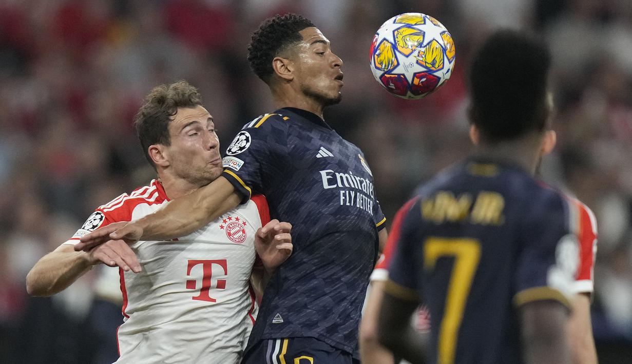 Gelandang Real Madrid, Jude Bellingham (tengah) mengontrol bola dibayangi gelandang Bayern Munchen, Leon Goretzka pada laga leg pertama semifinal Liga Champions 2023/2024 di Allianz Arena, Munich, Selasa (30/4/2024). (AP Photo/Matthias Schrader)