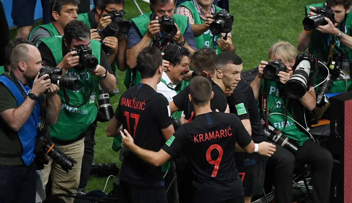 Ivan Rakitic (2kanan) berbincang dengan Yuri Cortez usai selebrasi gol pada semifinal Piala Dunia 2018 di Luzhniki Stadium, Moskow, (11/7/2018). Yuri jatuh saat perayaan gol skuat Vatreni tersebut. (AFP/Jewel Samad)